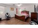 Bright bedroom featuring a large wooden bed frame, white walls, and a ceiling fan at 9124 W Williams St, Tolleson, AZ 85353