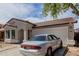Single-story home featuring a two-car garage and stone landscaping at 9124 W Williams St, Tolleson, AZ 85353