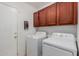 Bright laundry room showcasing a washer and dryer, alongside wooden cabinets for ample storage at 9124 W Williams St, Tolleson, AZ 85353