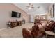 Comfortable living room featuring neutral walls, ceiling fan, and cozy leather seating at 9124 W Williams St, Tolleson, AZ 85353