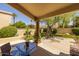 A serene backyard with a covered patio, glass top table and views of the desert landscaping at 10429 N 101St St, Scottsdale, AZ 85258
