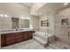 A relaxing bathroom with tile floors, granite countertop vanity, a tub, and glass enclosed shower at 10429 N 101St St, Scottsdale, AZ 85258