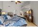 Spacious primary bedroom showcasing a blue patterned bedspread, hardwood flooring, and access to other areas of the house at 10429 N 101St St, Scottsdale, AZ 85258