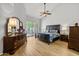 Serene bedroom features a dark wood bed frame, shuttered windows, and wood flooring, bathed in natural light at 10429 N 101St St, Scottsdale, AZ 85258