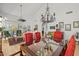 Elegant dining room featuring a glass-top table, red chairs, and a decorative chandelier in a well-lit, open-concept space at 10429 N 101St St, Scottsdale, AZ 85258