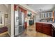 Open kitchen featuring stainless steel refrigerator, rich wood cabinets, island with white countertop, and travertine tile flooring at 10429 N 101St St, Scottsdale, AZ 85258