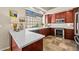 Well-lit kitchen showcasing dark wood cabinetry, stainless steel appliances, white counters, and a large garden window at 10429 N 101St St, Scottsdale, AZ 85258