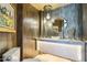 Stylish powder room boasts unique lighting, vanity, mirror, and artwork at 10651 E Fernwood Ln, Scottsdale, AZ 85262