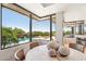 Dining area with large windows overlooking pool, spa, and desert views at 10651 E Fernwood Ln, Scottsdale, AZ 85262