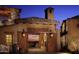 Charming exterior entrance with wooden gates, warm lighting, and landscaping at 10651 E Fernwood Ln, Scottsdale, AZ 85262