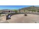 Circular stone patio with a firepit, perfect for outdoor gatherings against a scenic desert backdrop at 10651 E Fernwood Ln, Scottsdale, AZ 85262
