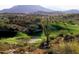 Lush green golf course with desert landscape, cacti and sand traps, framed by mountains at 10651 E Fernwood Ln, Scottsdale, AZ 85262