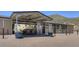 Covered horse paddock with a shaded seating area, showcasing equestrian facilities in a desert setting at 10651 E Fernwood Ln, Scottsdale, AZ 85262