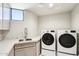 Functional laundry room with modern appliances, a sink, and plenty of counter space at 10651 E Fernwood Ln, Scottsdale, AZ 85262