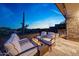Comfortable outdoor patio with stylish seating and a modern fire pit overlooking the desert at 10651 E Fernwood Ln, Scottsdale, AZ 85262