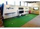 Indoor putting green area with various putters and monitors for golf analysis at 10651 E Fernwood Ln, Scottsdale, AZ 85262