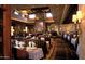 Cozy restaurant interior with striped booth seating, stone fireplace, and ambient lighting at 10651 E Fernwood Ln, Scottsdale, AZ 85262