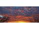 Vibrant sunset with dramatic, orange-tinged clouds filling the sky, viewed from a desert landscape at 10651 E Fernwood Ln, Scottsdale, AZ 85262