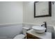 Modern bathroom featuring a wood vanity with vessel sink, white wainscoting, and black accents at 10925 E Toluca Ave, Mesa, AZ 85212