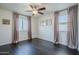 Bedroom showcases hardwood floors, large windows with curtains, a ceiling fan, and neutral walls at 10925 E Toluca Ave, Mesa, AZ 85212