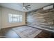 Bedroom with a wood-look accent wall, ceiling fan, and a large patterned rug at 10925 E Toluca Ave, Mesa, AZ 85212