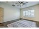 Neutral bedroom with a ceiling fan, a large window, and patterned rug at 10925 E Toluca Ave, Mesa, AZ 85212