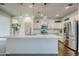 A view of the kitchen with white cabinets, an island, stainless steel appliances, and pendant lighting at 10925 E Toluca Ave, Mesa, AZ 85212