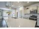 Kitchen island with seating, white countertops, stainless steel sink, and view of the living room at 10925 E Toluca Ave, Mesa, AZ 85212