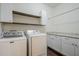 Well-lit laundry room with modern appliances, granite counters, and storage cabinets at 10925 E Toluca Ave, Mesa, AZ 85212