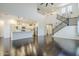 Open-concept living room with dark wood floors, high ceilings, and a view of the modern kitchen and staircase at 10925 E Toluca Ave, Mesa, AZ 85212