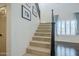 Carpeted staircase with black banister leads to the upper level of the home, with ample light at 10925 E Toluca Ave, Mesa, AZ 85212
