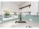 Modern kitchen sink features white countertop, stylish faucet, and open shelving above at 11000 N 91St Ave # 20, Peoria, AZ 85345