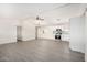 Open-concept living space with new gray flooring, white walls, and a modern kitchen in the background at 11000 N 91St Ave # 20, Peoria, AZ 85345