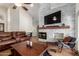 Spacious living room featuring a cozy fireplace and a comfortable leather sectional sofa at 11085 E Mary Katherine Dr, Scottsdale, AZ 85259