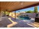 Covered patio overlooking a sparkling pool and landscaped backyard featuring a stone privacy wall at 11085 E Mary Katherine Dr, Scottsdale, AZ 85259