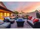 A cozy backyard with a modern fire pit and comfortable seating overlooks a sparkling pool surrounded by privacy walls at 11085 E Mary Katherine Dr, Scottsdale, AZ 85259