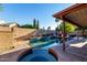 Backyard pool and spa featuring decorative stone border, mature landscaping, and privacy walls at 11085 E Mary Katherine Dr, Scottsdale, AZ 85259