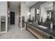 Modern community bathroom featuring a double vanity with attractive dark countertops at 11300 N Casa Dega Dr # 1005, Surprise, AZ 85388