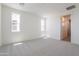 Bright bedroom featuring neutral carpet, two windows, and ensuite bathroom entrance at 11300 N Casa Dega Dr # 1005, Surprise, AZ 85388