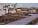 View of the Sterling Grove entrance featuring a sign, trellis, and well-maintained landscaping at 11300 N Casa Dega Dr # 1005, Surprise, AZ 85388