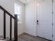 Bright entryway featuring a white front door, wood-look floors, and staircase at 11300 N Casa Dega Dr # 1005, Surprise, AZ 85388