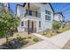 Charming townhome with a red door, black accents, balcony, and manicured landscaping at 11300 N Casa Dega Dr # 1005, Surprise, AZ 85388