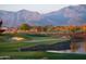 Picturesque golf course with a pond, mature trees, and mountain scenery at 11300 N Casa Dega Dr # 1005, Surprise, AZ 85388
