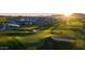 Scenic golf course view at sunset featuring lush green grass, sand traps, and homes in the background at 11300 N Casa Dega Dr # 1005, Surprise, AZ 85388