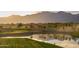 Beautiful golf course featuring a pond, sand traps, and scenic views in the background at 11300 N Casa Dega Dr # 1005, Surprise, AZ 85388