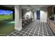 Golf simulator with bar, TV, and chairs featuring modern carpet design at 11300 N Casa Dega Dr # 1005, Surprise, AZ 85388