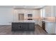 Open kitchen with white cabinets, stainless steel appliances, a gray island, and hardwood flooring at 11300 N Casa Dega Dr # 1005, Surprise, AZ 85388