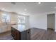 Open-concept living area featuring a kitchen island, hardwood floors, and large windows for natural light at 11300 N Casa Dega Dr # 1005, Surprise, AZ 85388