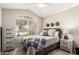 Bedroom with bright window, side table, and tiled flooring at 11669 W Pine Mountain Ct, Surprise, AZ 85378