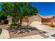 Beige single-story home with a two-car garage, desert landscaping, and a concrete driveway at 11669 W Pine Mountain Ct, Surprise, AZ 85378